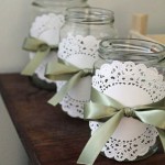 mason jars with satin green ribbon and white doilies