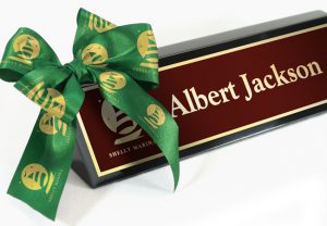 Wrapping up an executive desk wedge with personalized satin ribbon rolls.