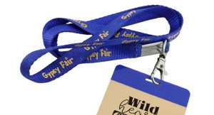 A blue lanyard customized with a fair logo to be worn by an attendee or event goer.