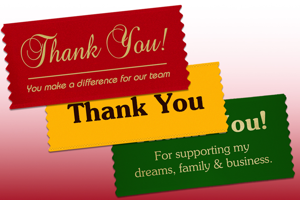 Three custom badge ribbons with imprinted text to say thank you.