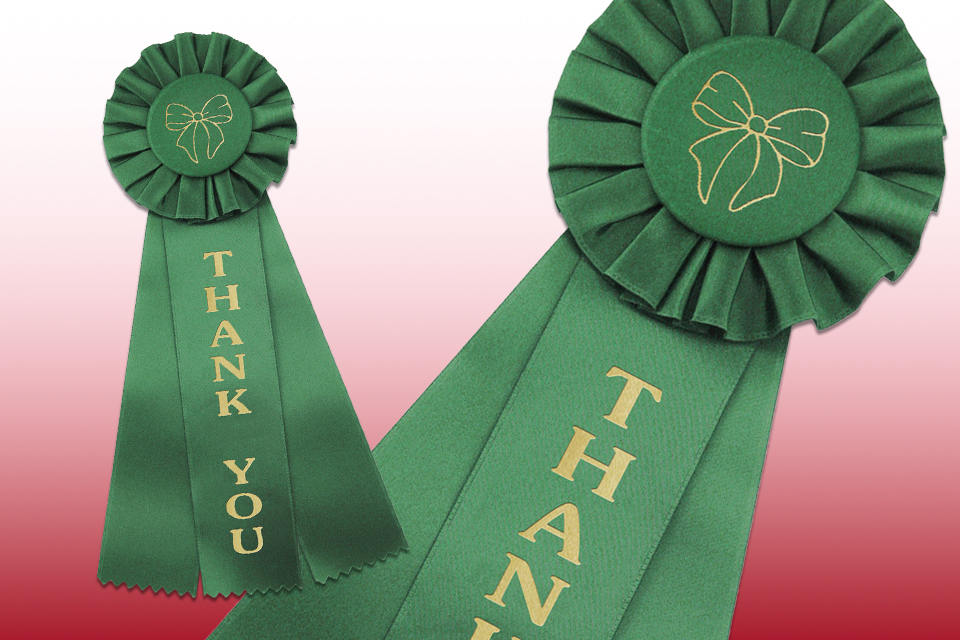 An Ideal three streamer rosette ribbon customized with a bow in the center and Thank you down the middle.